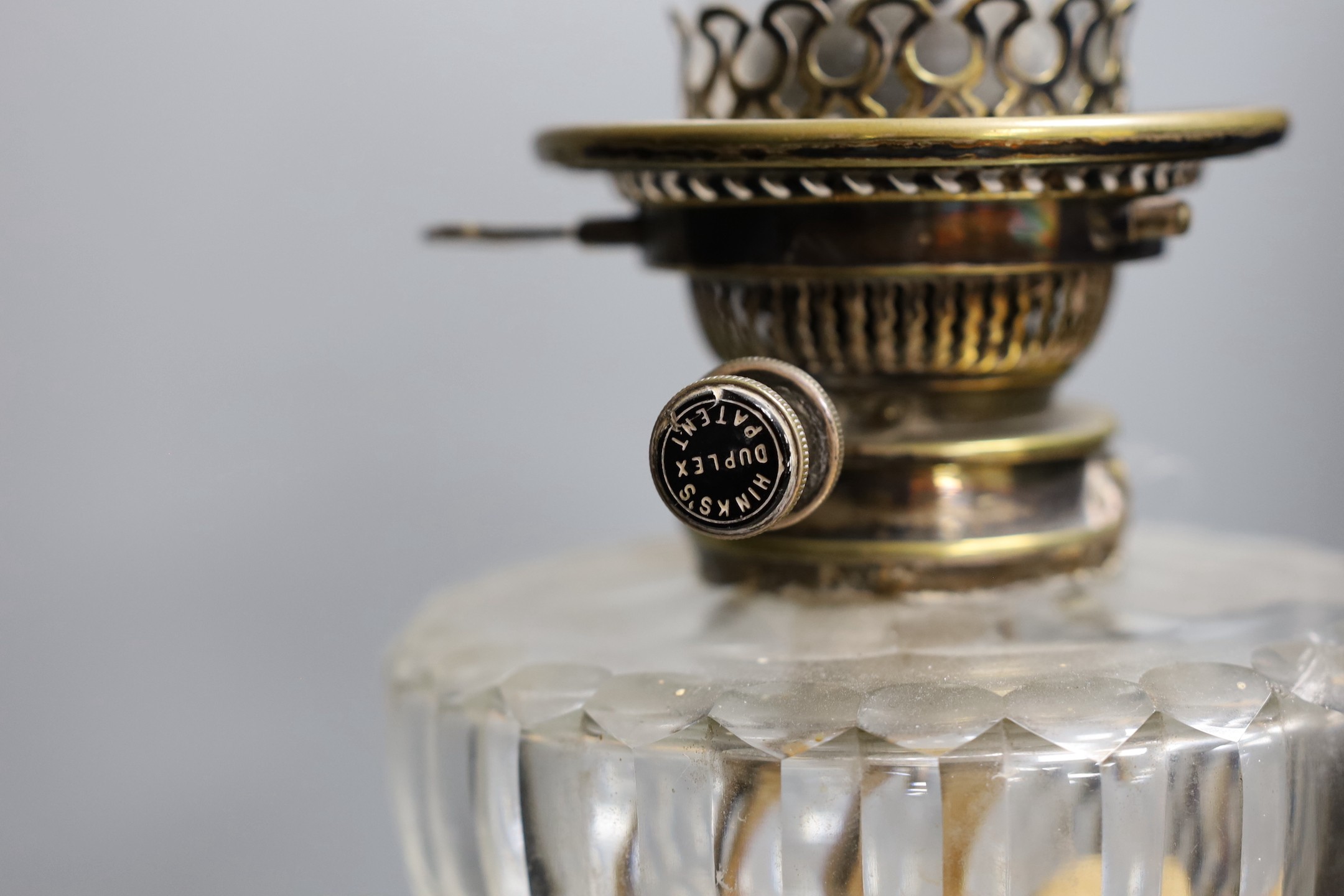 A Victorian silver plated Corinthian column oil lamp, with a glass reservoir